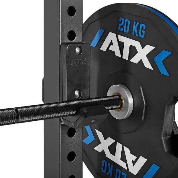 Close-up of a weightlifting setup with a 20 kg ATX weight plate on a barbell, secured on an ATX® Half Rack. Textured grip of the barbell and part of the rack are visible.