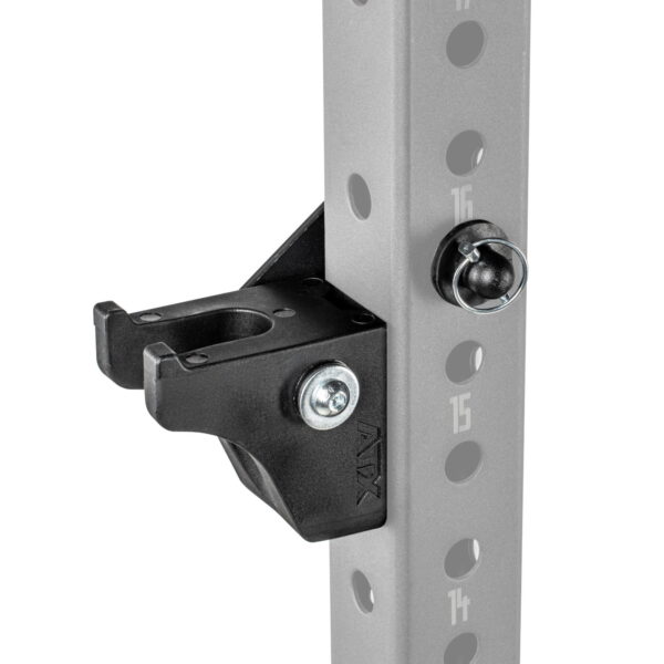 Close-up of the ATX® Bar Holder, a black metal bracket attached to a gray vertical pole with numbered holes, used in exercise equipment. It is secured with bolts and has a hook-like design for holding weights or accessories.
