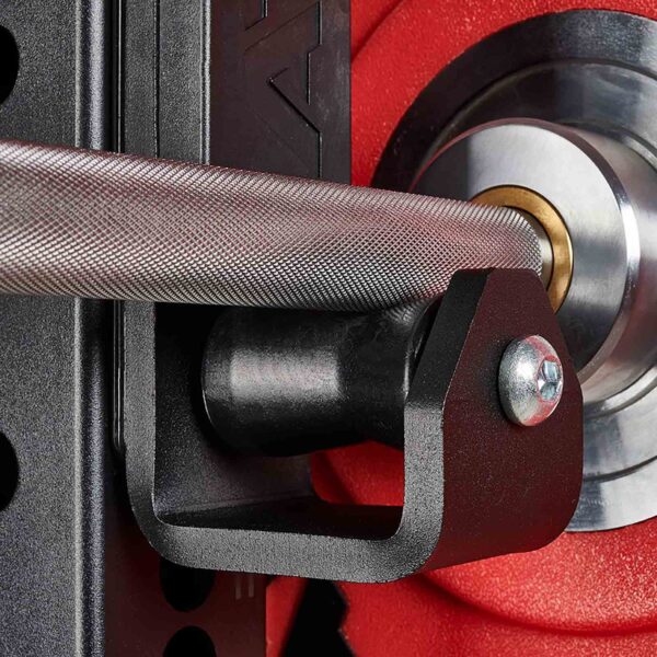 Close-up of the ATX® Roller J-Hooks Universal holding a barbell with a red weight plate in the background. The textured grip and round shape of the plate are visible, along with a black metal holder and shiny bolt.