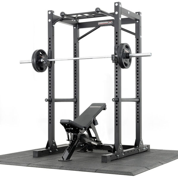 A black power rack with a pull-up bar, loaded barbell, and adjustable bench on Shock & Sound Tile 30mm System rubber flooring, perfect for any home gym or fitness center.
