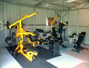 Al's Home Gym featuring a Powertec Multi System, Ironmaster dumbbells, Powertec Vertical gym. It is in a large shed