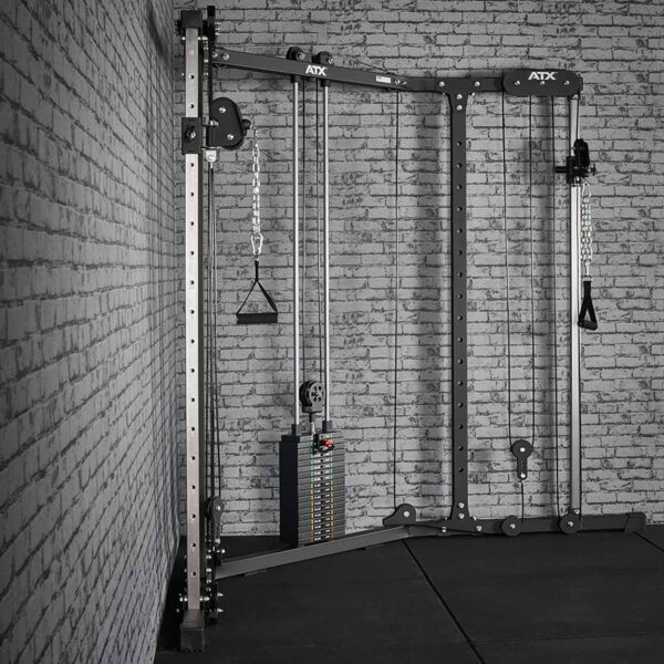 The ATX® Cable Crossover Weight Stack 90 kg, set against a brick wall, has adjustable pulleys and handles with chains for versatile workouts, all on black mats.
