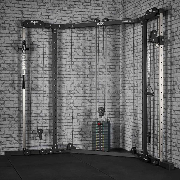 A home gym setup includes the ATX® Cable Crossover Weight Stack 90 kg, a dual pulley system with adjustable weights, set against a brick wall. The equipment is black with silver accents and ideal for strength training exercises.