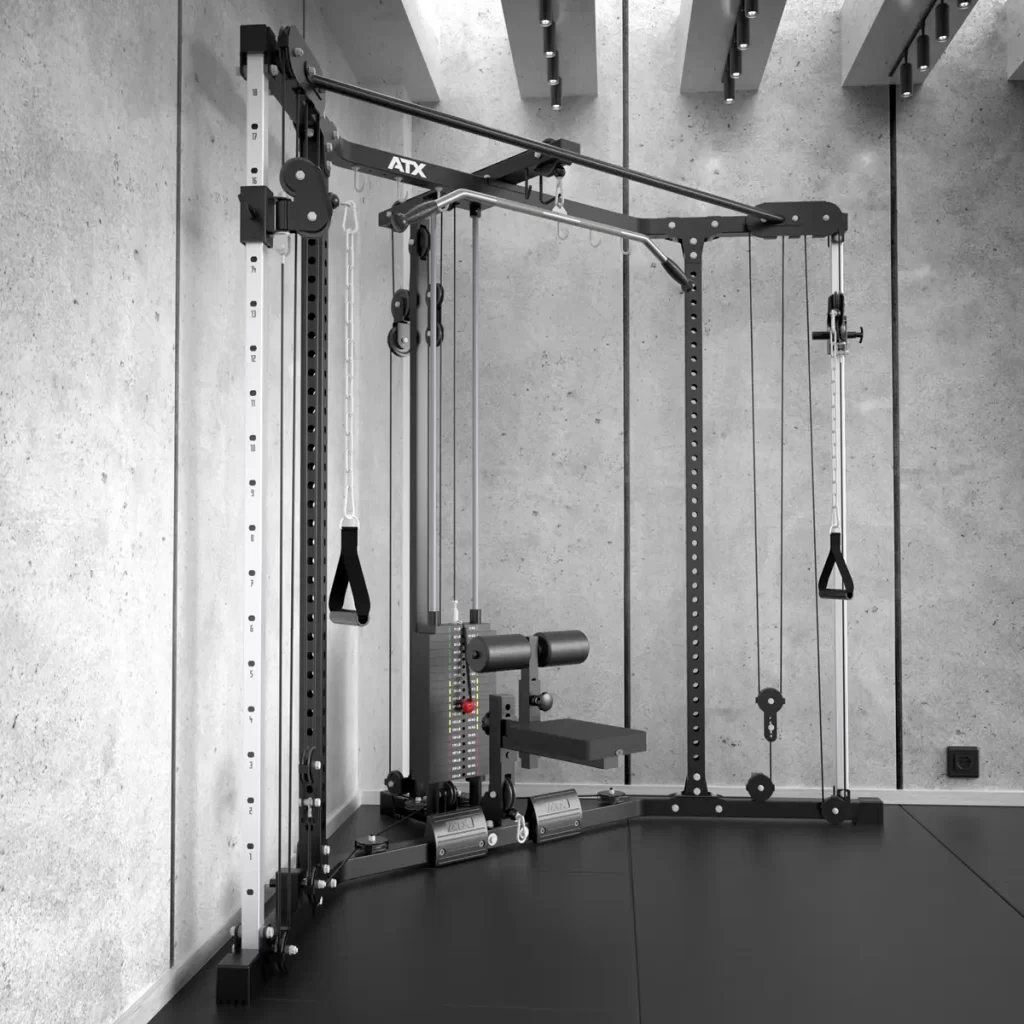 The ATX® Cable Corner Station in a minimalist setting features cable pulleys, adjustable weights, and handles for diverse exercises. The concrete finish and ceiling lights add an industrial yet sleek touch to the room.