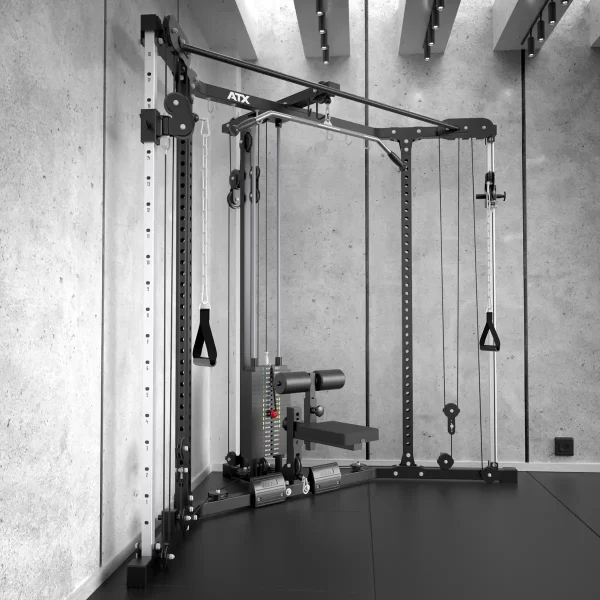 The ATX® Cable Corner Station in a minimalist setting features cable pulleys, adjustable weights, and handles for diverse exercises. The concrete finish and ceiling lights add an industrial yet sleek touch to the room.