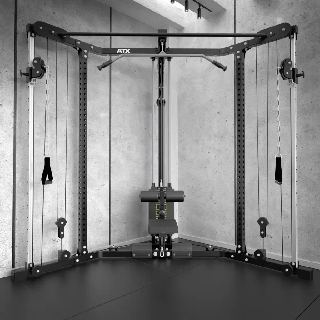 The ATX® Cable Corner Station, with a durable metal frame and adjustable pulleys, is mounted against a concrete wall. It includes two handles for versatile workouts and boasts a sleek black design suitable for any gym setting.