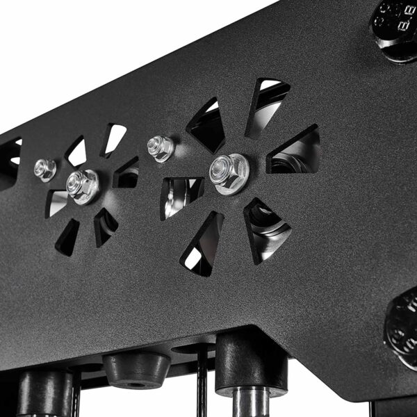 Close-up of a black mechanical component from a cable station, featuring two circular cutouts with geometric designs. Visible bolts and screws enhance its industrial appearance. The plain background highlights the detailed metalwork, emphasizing the precision typical of cable weight machines.