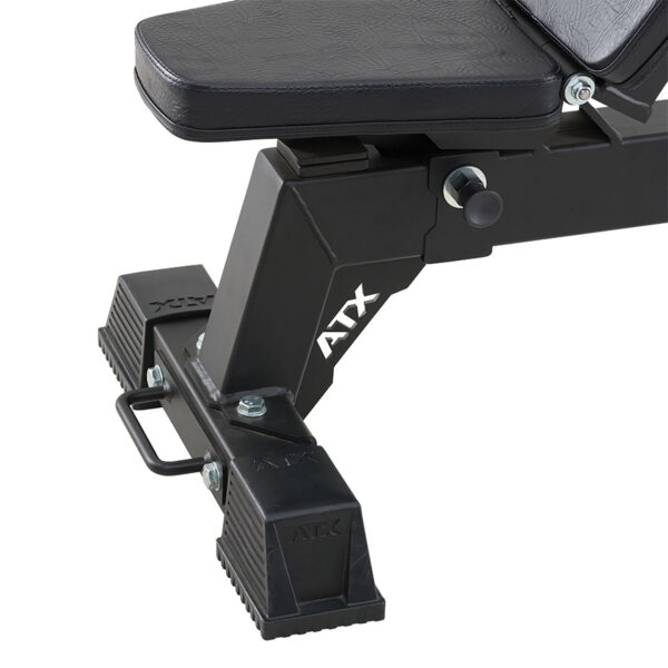 Close-up of the base and adjustable mechanism of the ATX® Utility Bulls Bench, featuring a ATX logo on the side. The black workout bench has a sturdy metal frame and rubberized foot grips for stability.