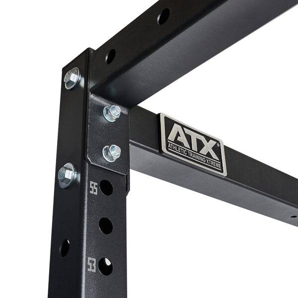 Close-up of a black metal frame from the ATX® Power Rack 755 Short Distance, showcasing the ATX logo. The sturdy construction features several bolts and holes, highlighting its robust design for Athletic Training Xtreme.