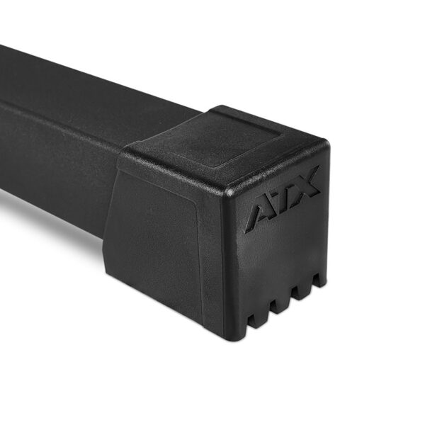 Close-up of a black, square-shaped, ridged object embossed with ATX on its surface. The white background accentuates the sleek and angular design of the ATX® HRX-620 Half Rack System Pin Loaded 115 kg.