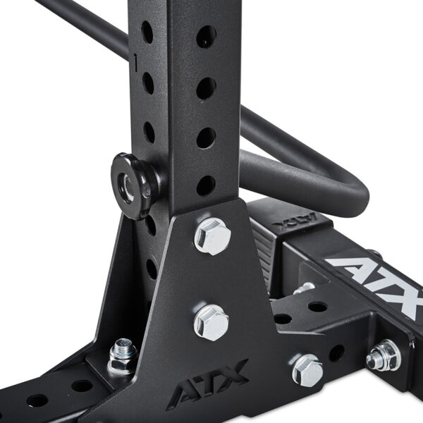 Close-up of the ATX® Squat Stands Brace, a black metal gym rack featuring adjustable holes and secured bolts. The ATX logo is visible on various parts, showcasing its sturdy construction and design.