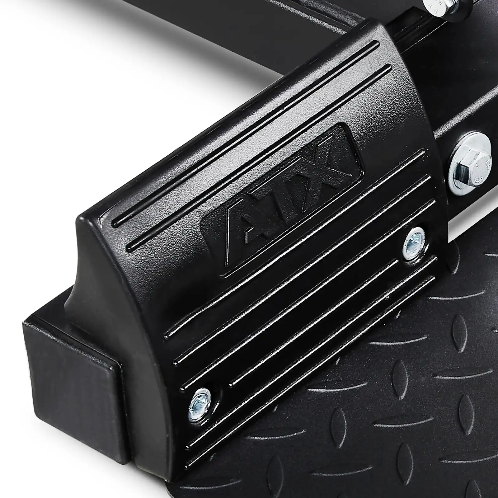 Close-up of a black metal footplate with textured grip, featuring the brand name ATX embossed in a raised design. The background reveals parts of a Lat Pulldown and Row Machine, showcasing screws and bolts intricately arranged.