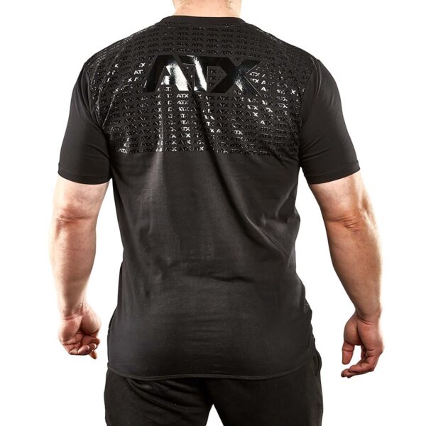 Rear view of someone in an ATX® Grip Shirt. The black shirt has a textured pattern with ATX across the back shoulders and a large ATX logo at the center. They pair it with black pants for a cohesive look.
