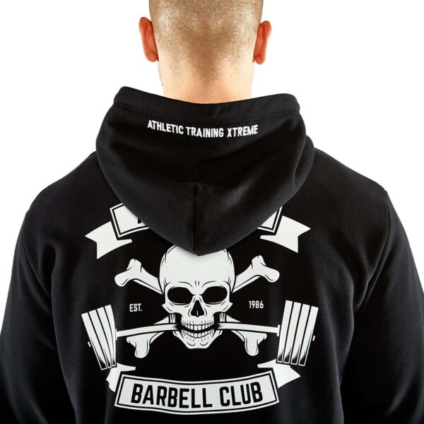 A person is wearing an ATX® Black Hoodie, displaying a back design with a skull, crossed barbells, and the text Barbell Club and Athletic Training Xtreme Est. 1986, while facing away from the camera.