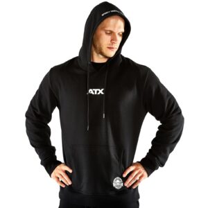A person in an ATX® Black Hoodie, hood up and hands on hips, features a white ATX logo on the chest with a small graphic on the lower pocket, set against a plain white background.