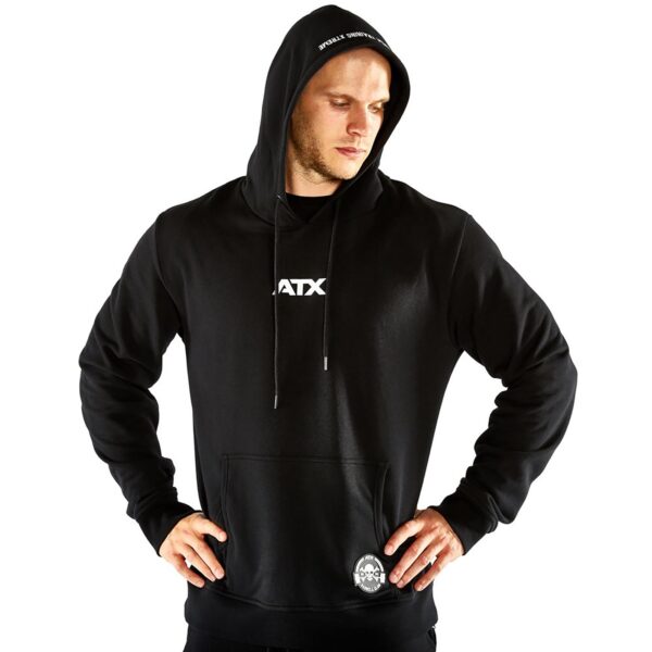 A person in an ATX® Black Hoodie, hood up and hands on hips, features a white ATX logo on the chest with a small graphic on the lower pocket, set against a plain white background.