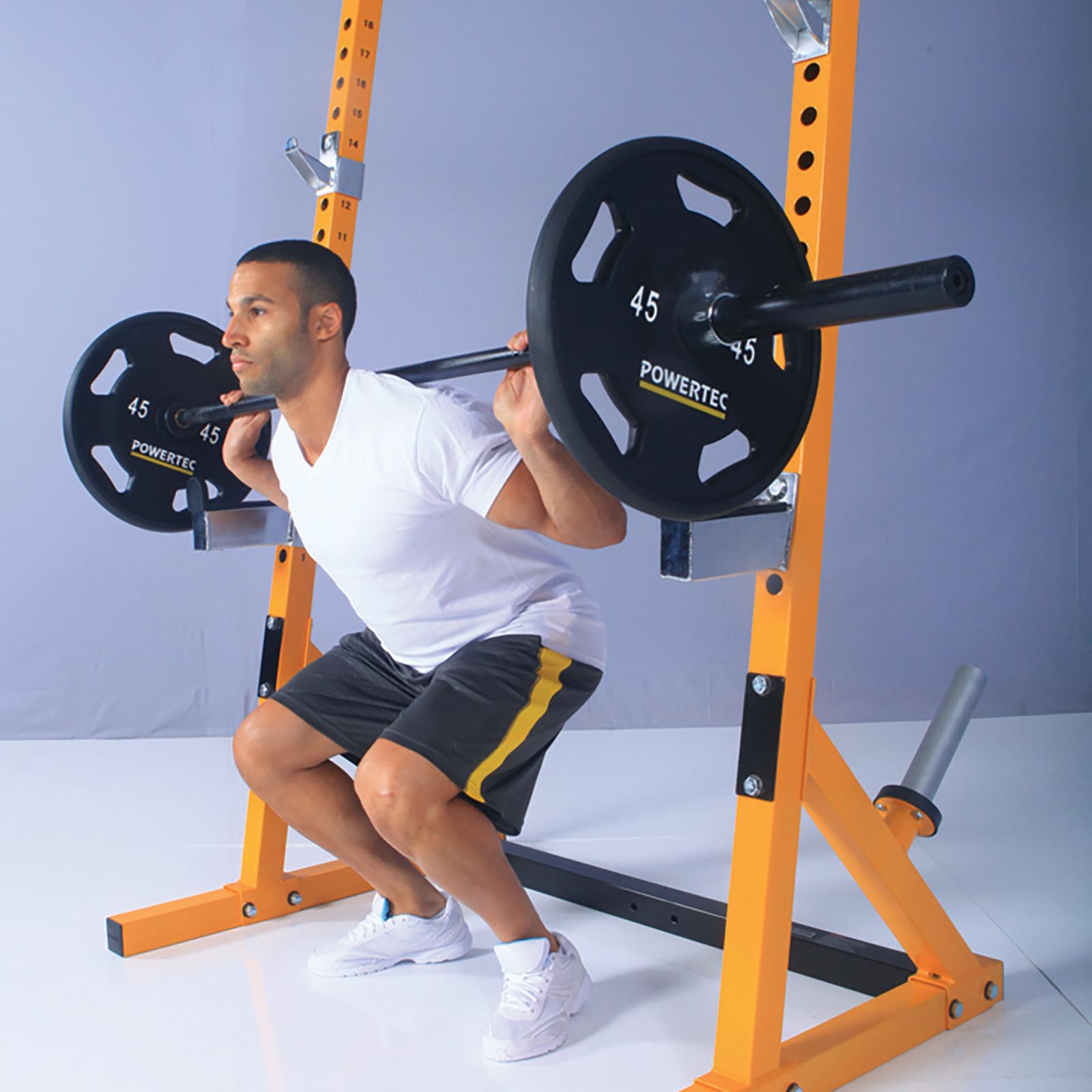 Man doing barbell squats on a half rack