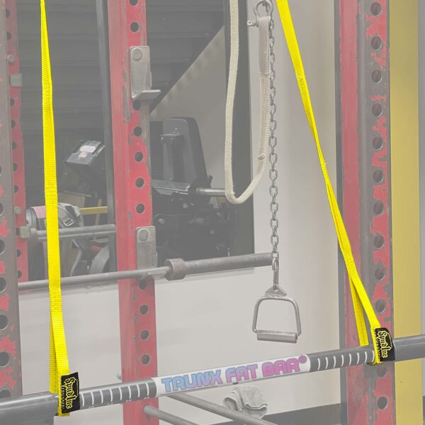 A gym setup featuring a Spud Pittsburgh Jammer with a Fat Bar on yellow straps in a red rack, plus a chain handle. Exercise equipment is visible in the background.