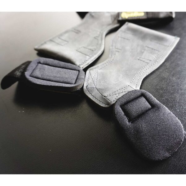 Close-up of Spud Inc The Gripazz, a pair of black and gray weightlifting wrist straps with padded grips, showcasing detailed stitching along the edges on a dark surface.
