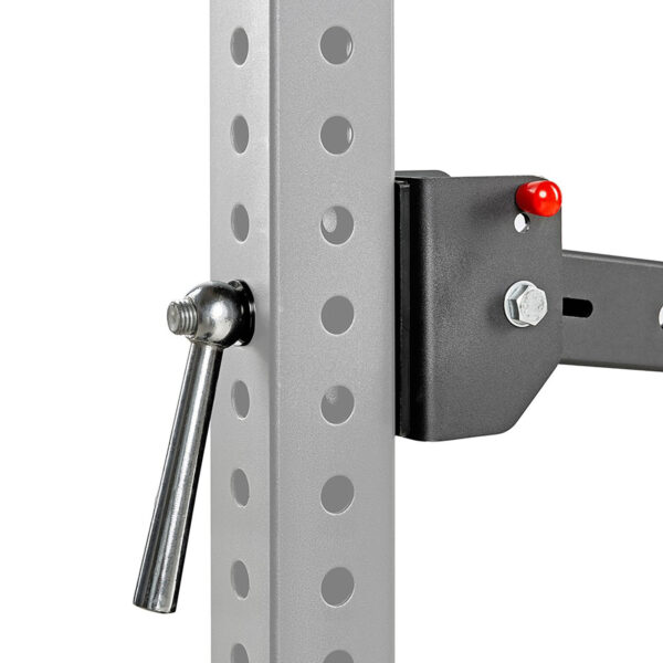 Close-up of a metallic adjustment pin in a vertical beam with circular holes, featuring a black bracket with a red-tipped element. This setup is part of the ATX® Belt Squat Option, likely used for exercise or gym purposes.