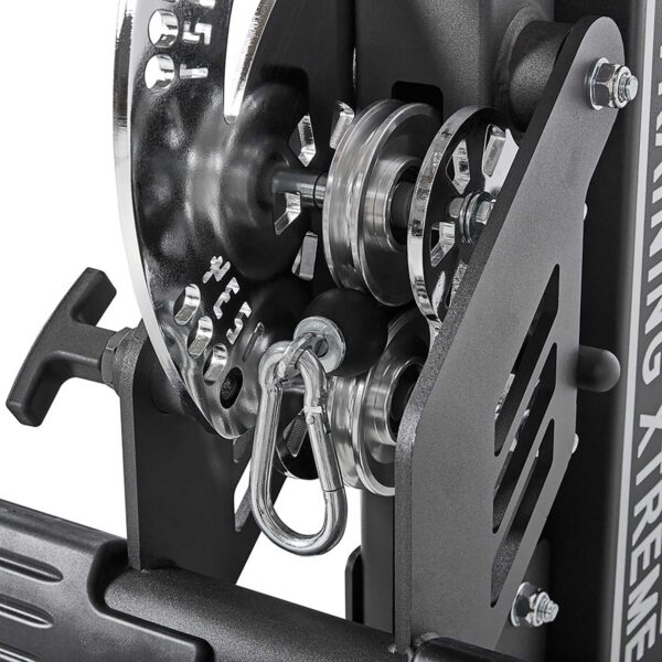 Close-up of the ATX® Trinity Tower 135 kg with a black and silver pulley mechanism, showcasing gears, hooks, and cables that highlight the detailed engineering of this exercise machine.