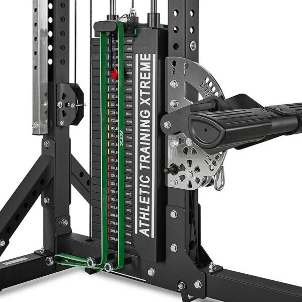 A close-up of a weight stack from an ATX® Trinity Tower 135 kg machine shows multiple weight plates, adjustment pins, and a cable system designed for resistance training and strength exercises.