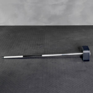 The Ironmaster Quick Lock Mace Handle, featuring a robust, long metal grip and large square rubber head, rests on a textured dark gray floor with a plain gray wall in the background.