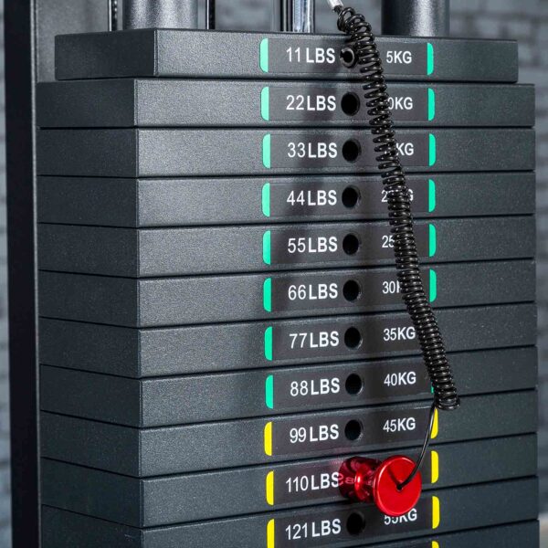A stack of weight plates on a gym machine features Weight Stack Stickers KG/LBS. A red pin is inserted in the 77 lbs (35 kg) slot, attached with a coiled black cord.