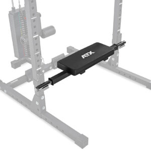 A gym setup includes a black bench pad with ATX printed on it, attached to an adjustable cable crossover machine. The ATX® Hip Thruster Attachment complements the sturdy metal frame and visible pulley system in the background.