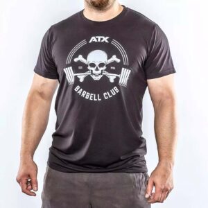 Someone is wearing an ATX® Barbell Club T-Shirt in black, featuring a skull with barbells and the text ATX Barbell Club, along with Est. 1986 above the skull, against a plain white background.