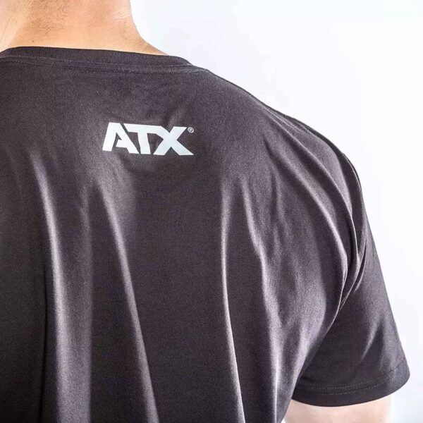 Someone is wearing the ATX® Barbell Club T-Shirt Black, featuring a white ATX logo on the back, seen from behind against a simple light background.