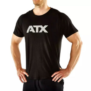 A person wearing an ATX® Training Shirt BLACK, featuring the letters ATX on the front, stands with hands on hips against a plain white background.