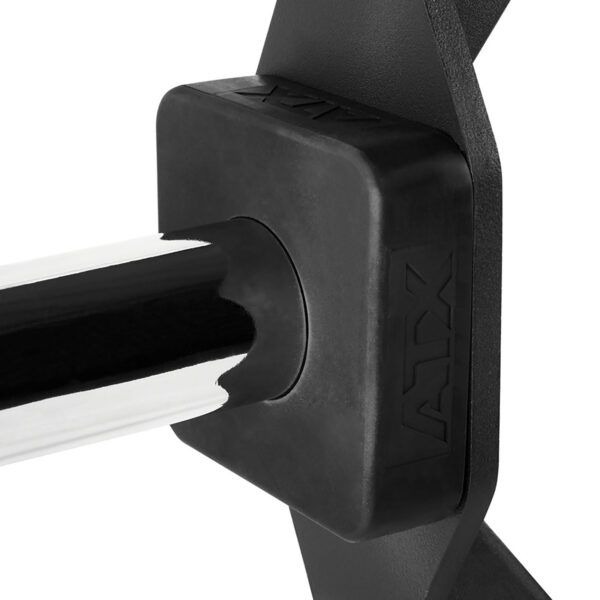 Close-up of a black hex barbell with a square protective cover labeled ATX. The barbell, resembling a trap bar, is attached to a component with angular design elements, highlighting the gym equipment details.