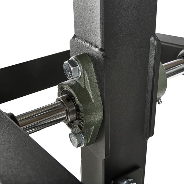 Close-up of the ATX® MultipleX Multi Gym - 700, showcasing a metallic rod and bearing assembly on a robust dark metal frame. Precision engineering and durability are highlighted by bolt connections.