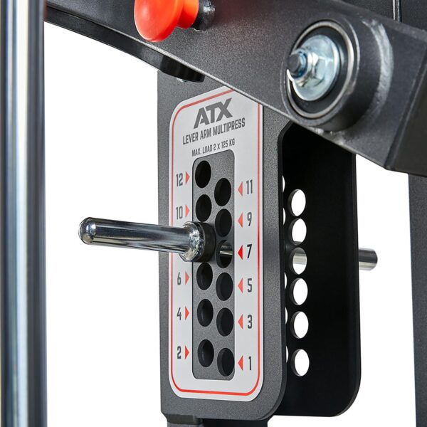 Close-up of a weight selector plate on a gym machine, showing various numbered weights with the pin at position 7. The plate is labeled ATX® MultipleX Multi Gym - 700.