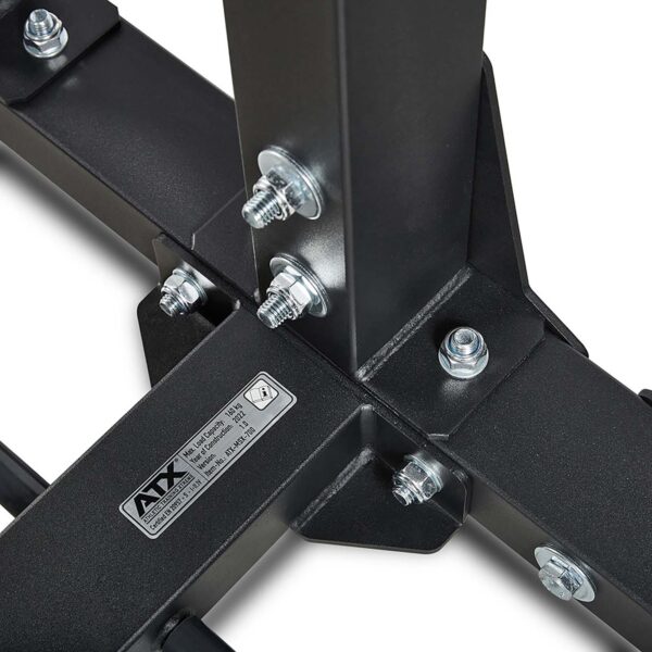 Close-up of the ATX® MultipleX Multi Gym - 700s metal structure, featuring bolts and nuts securing its joints. A label with text is seen on one beam, highlighting its sturdy and industrial design with a matte black finish.