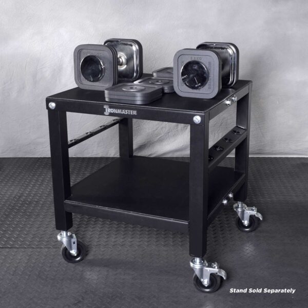 The Ironmaster 75 LB Quick-Lock Adjustable Dumbbell Set, without the stand, is organized on a black wheeled rack featuring two levels: dumbbells on top and weight plates below. The floor has a textured rubber mat pattern.