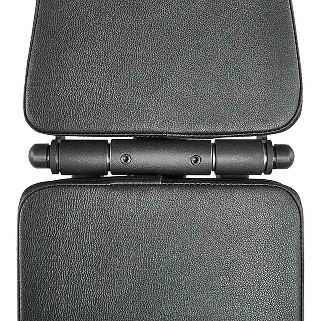 Close-up of the ATX® FID Bench 520 2.0, highlighting its black textured hinge and metal pivot mechanism. The bench folds flat, revealing padded sections with visible stitching details.