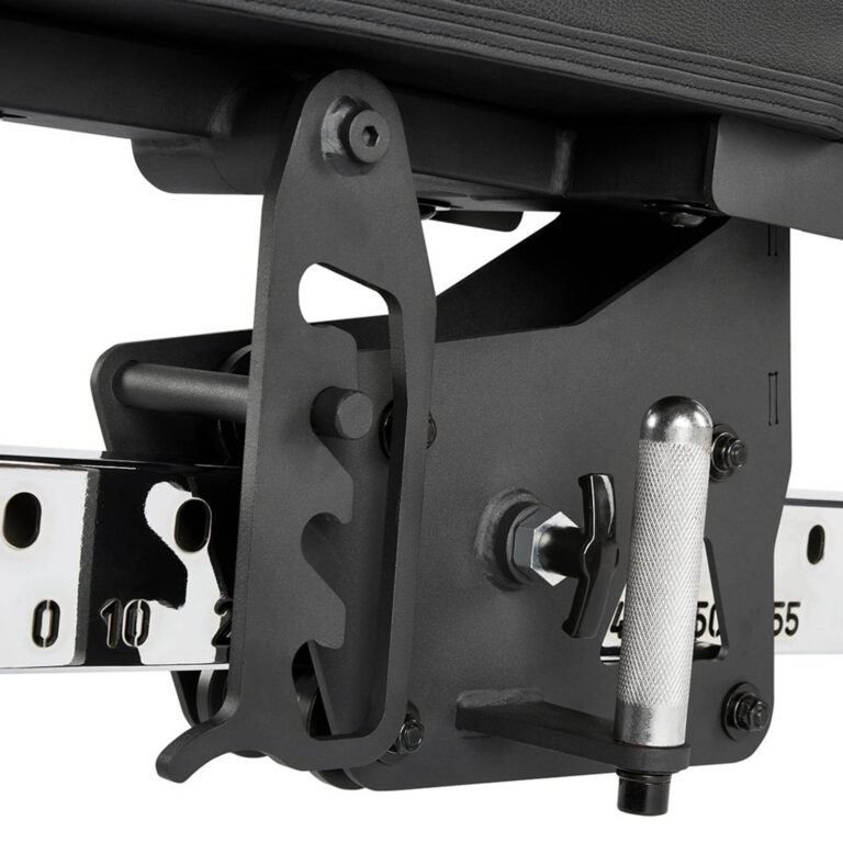 Close-up of a black adjustable mechanism on a fid bench, featuring a textured silver handle and numbered metal rail for precise positioning. The apparatus includes a series of gears and screws for fine-tuning the bench settings.
