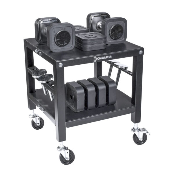 The Ironmaster QLDB Stand PRO is a black, wheeled cart with two shelves and a sturdy metal frame. It holds square Ironmaster adjustable dumbbells, while barbells are neatly organized on the sides.