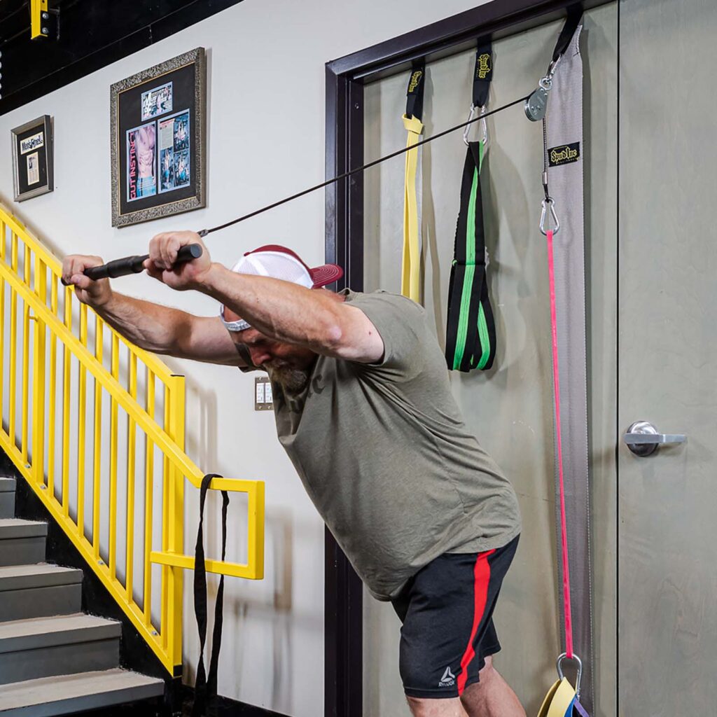 Spud doing overhead triceps extensions on the door jammer