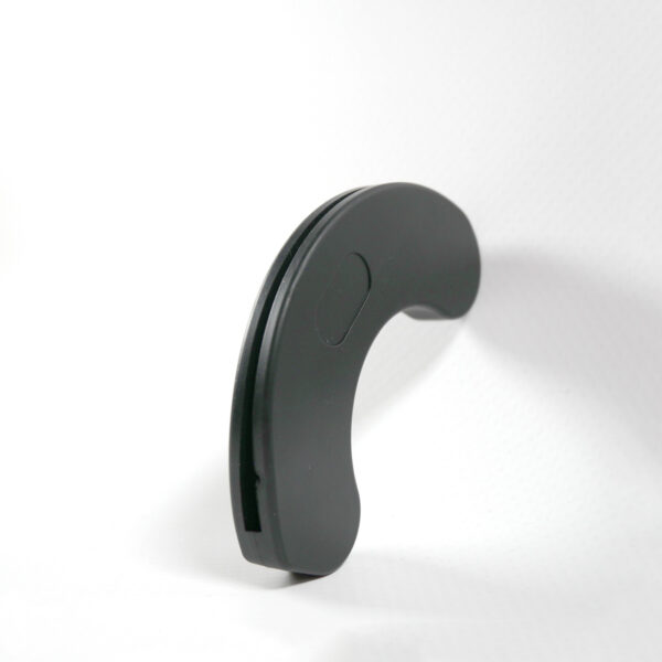 A black, curved object identified as a Dumbbell Handle Seat stands upright on a white surface against a plain white background in a minimalist, abstract shape.
