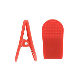 The Treadmill Safety Key Clip, in red plastic, is shown from two angles: a side view highlighting its hinge mechanism and another revealing its textured grip surface.