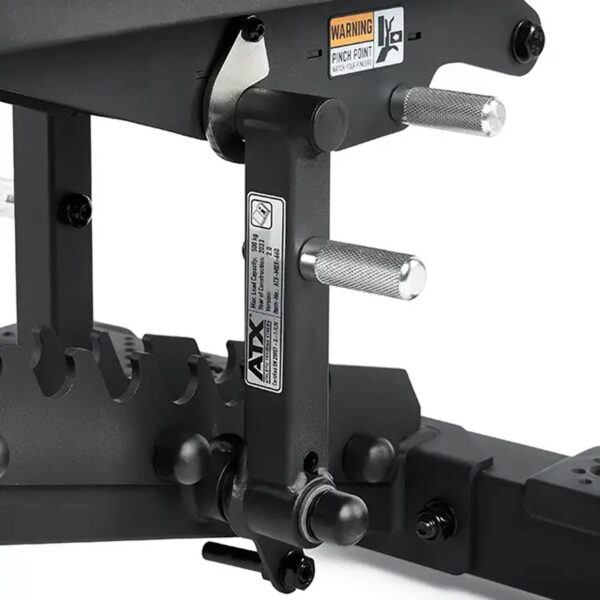 Close-up of the ATX® Commercial FID Bench ATX-MBX-660 mechanism with metal handles and a warning label. The matte black finish and adjustable bolts ensure stability for strength training, making it ideal for use with a flat incline bench setup.
