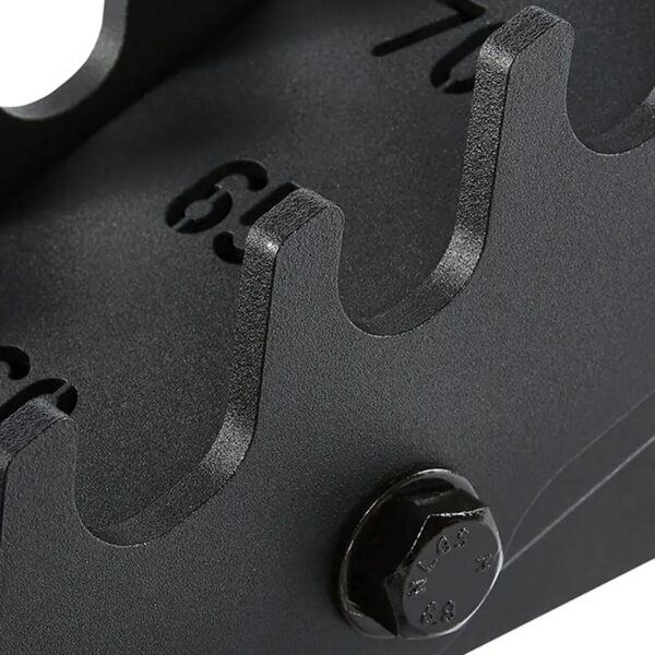 Close-up of a black, textured metal surface on the ATX® Warrior Bench 2.0, featuring a bolt and evenly spaced numbered notches (6-9) in a curved design, resembling a gear or mechanical component.