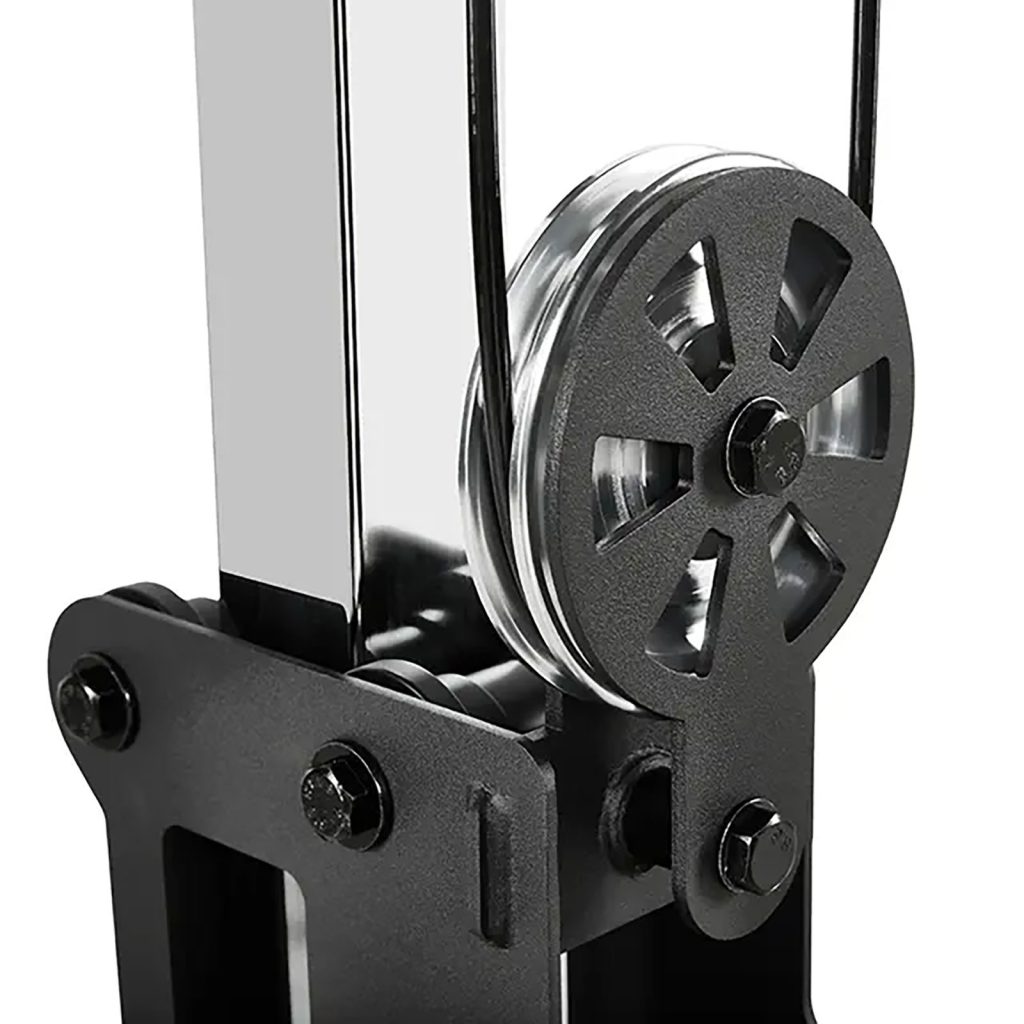 Close-up of a black and silver pulley system with a shiny metal finish, reminiscent of those on a pectoral fly machine. The pulley wheel is prominently displayed, showcasing its detailed design and attached cables.