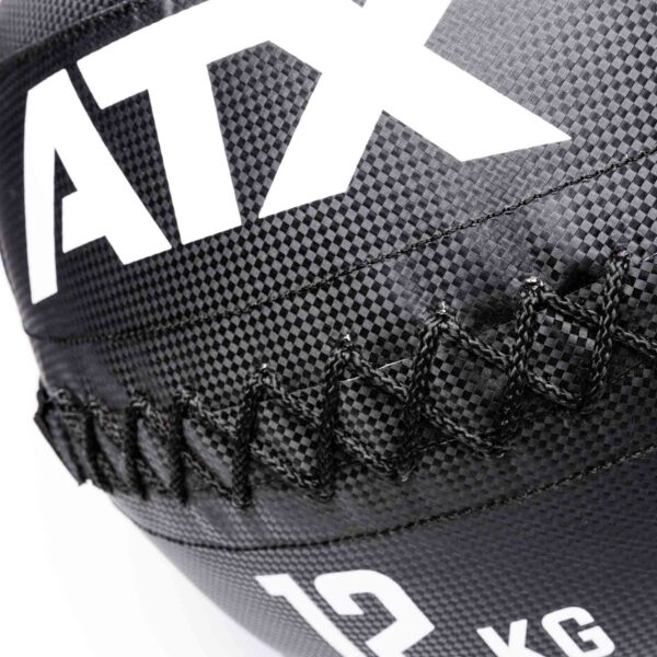 Close-up of a black and white ATX® Wall Balls PVC with the letters ATX, a visible stitched seam, and a textured grid-like pattern. The ball is weighted at 12 kg.