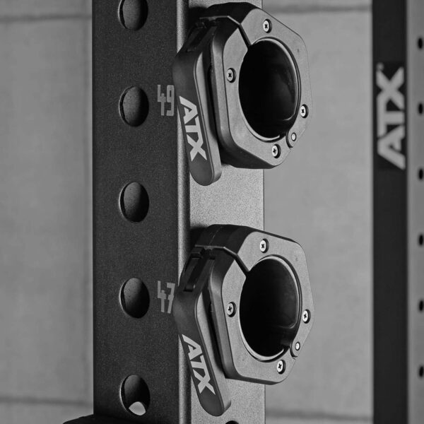 Close-up of sleek black ATX® Magnetic Collar 50mm clamps securing weights on a rack with numbered holes, showing numbers 47 and 49, with precision.
