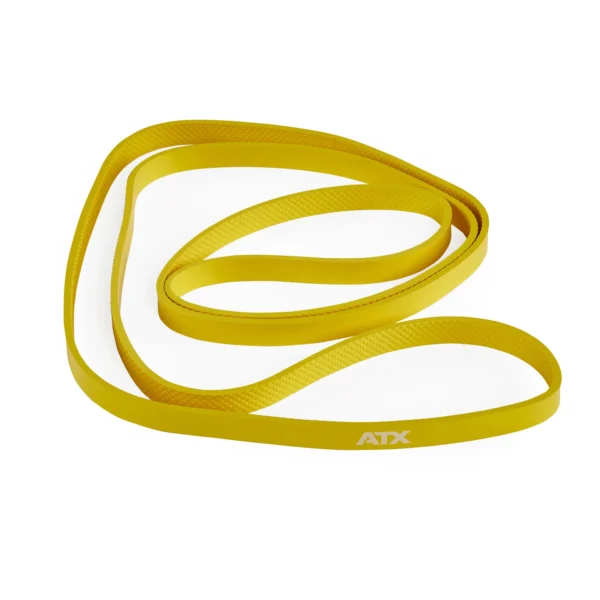A long, yellow ATX® Latex Free Resistance Band - 9 Levels is coiled loosely against a white background. The band is flat and seems ideal for fitness exercises or stretching.