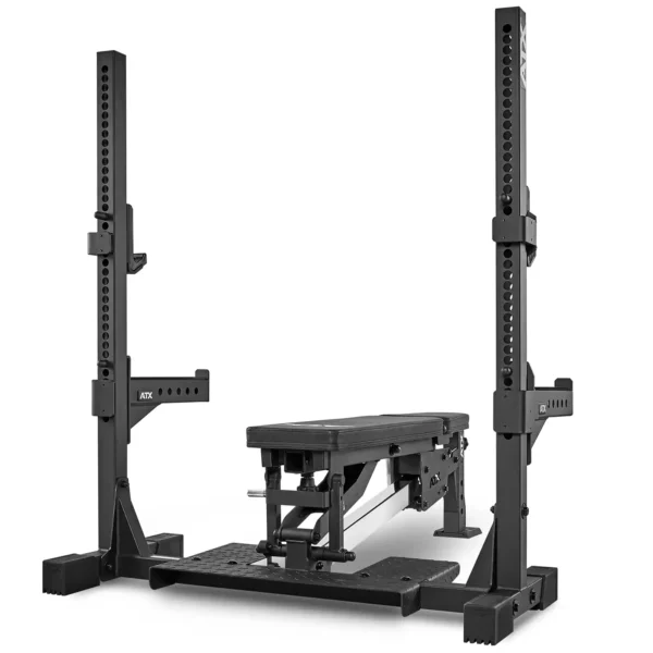 The ATX® Adjustable Bench Press is a black commercial bench with a sturdy steel frame and adjustable height support racks. Its designed for durability and perfect for strength training exercises like bench presses in a squat rack setup.